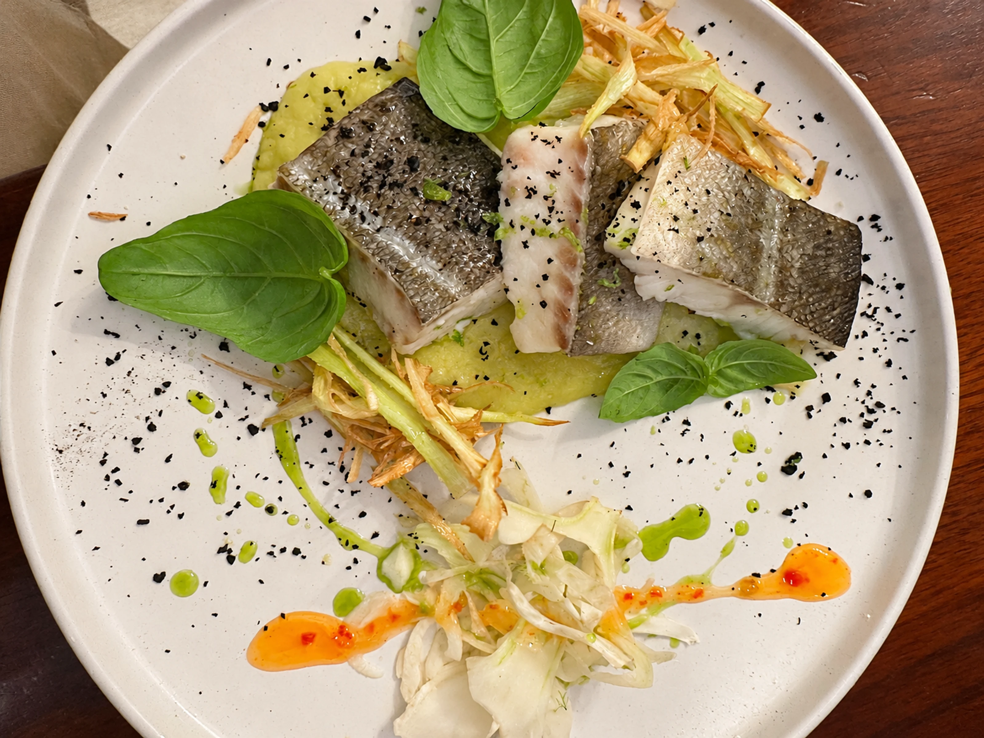 Un piatto della cucina di Manu con pesce e basilico
