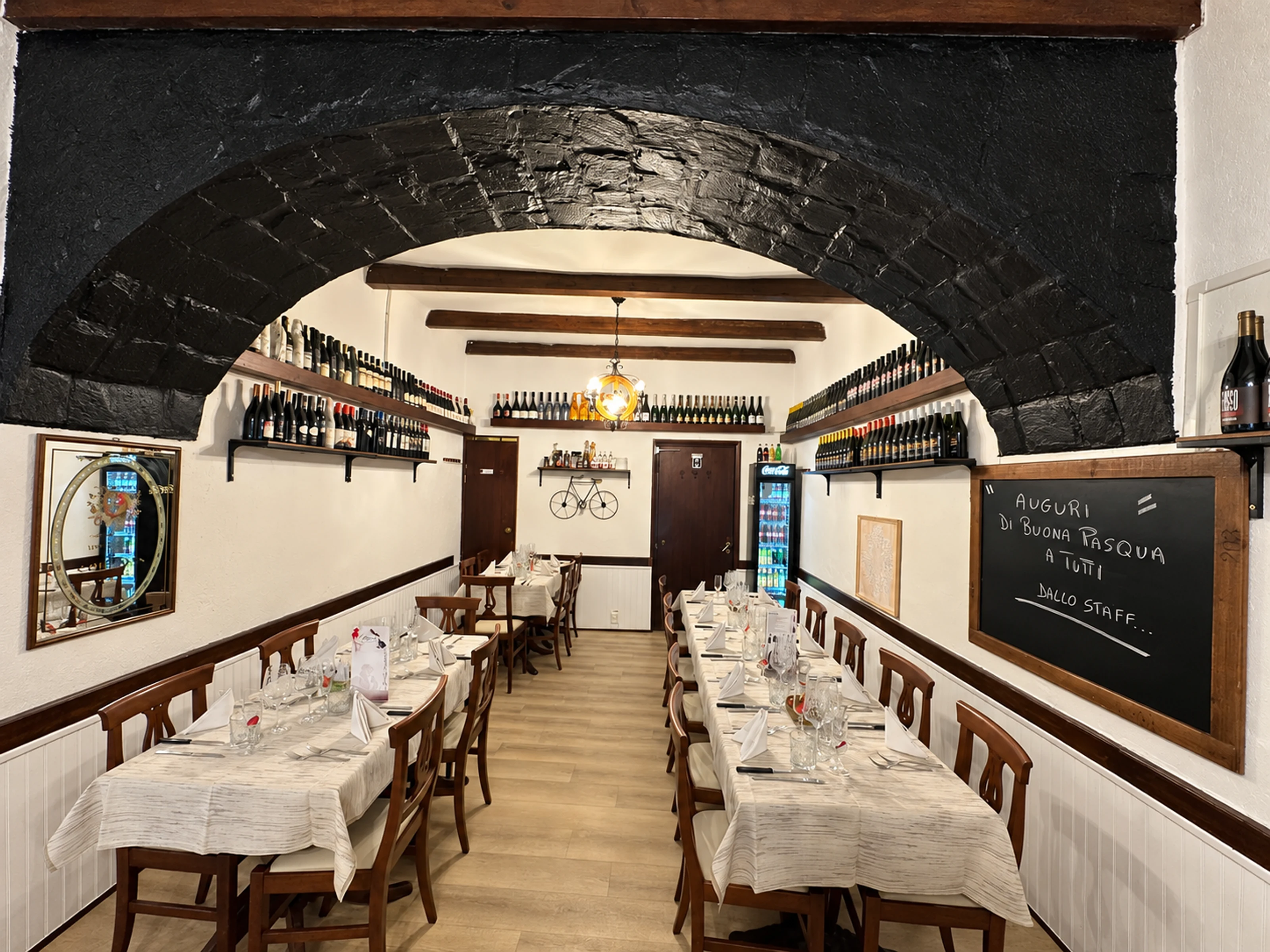 La sala dell’hostaria con l’arco di pietra e le bottiglie